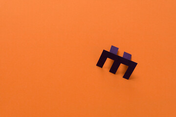 paper object (m, e, w, u ?) on an orange background with space