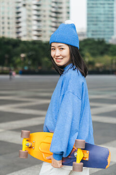 Woman holding a skateboard