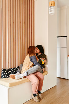 Lesbian couple kissing at home