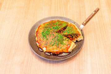 Okonomiyaki is a Japanese food that consists of a dough with ingredients cooked on the grill. The word okonomiyaki is made up of the honorifics o, konomi, and yaki, meaning 