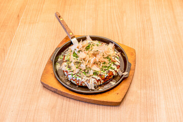 Okonomiyaki is a Japanese food that consists of a dough with ingredients cooked on the grill. The word okonomiyaki is made up of the honorifics o, konomi, and yaki, meaning 