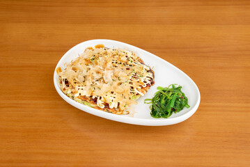 Okonomiyaki is a Japanese food that consists of a dough with ingredients cooked on the grill. The word okonomiyaki is made up of the honorifics o, konomi, and yaki, meaning 