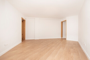Fototapeta na wymiar Large empty room with two oak doors and light colored wooden flooring