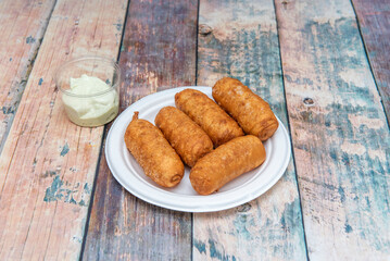 tequeño is a fried breaded cheese stick or spear of bread dough with white cheese stuffed in the middle, and is a popular meal or snack in Venezuela