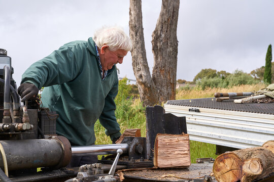 Firewood being split by senior man