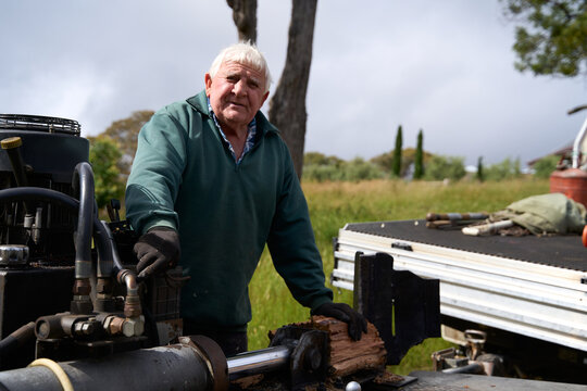 Senior man using wood splitter 