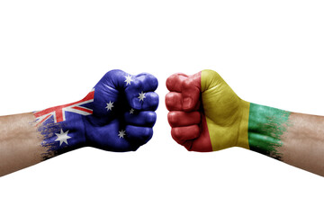 Two hands punch to each others on white background. Country flags painted fists, conflict crisis concept between australia and guinea