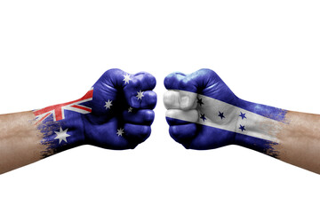 Two hands punch to each others on white background. Country flags painted fists, conflict crisis concept between australia and honduras