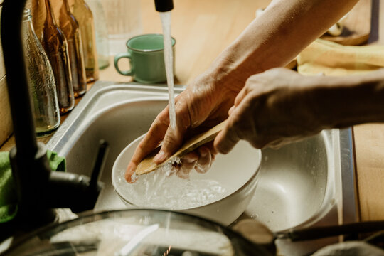 Man washing dishes at home kitchen
