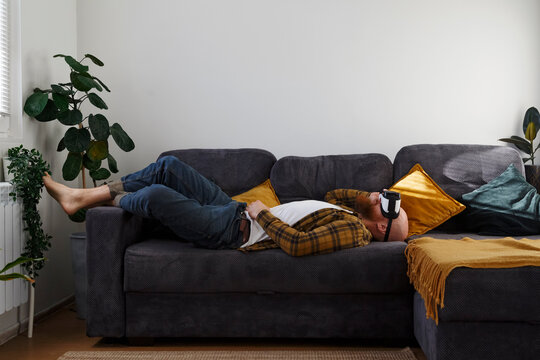 Man relaxing on sofa in VR headset