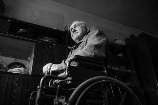 Physically disabled man sitting in his wheelchair - Powered by Adobe