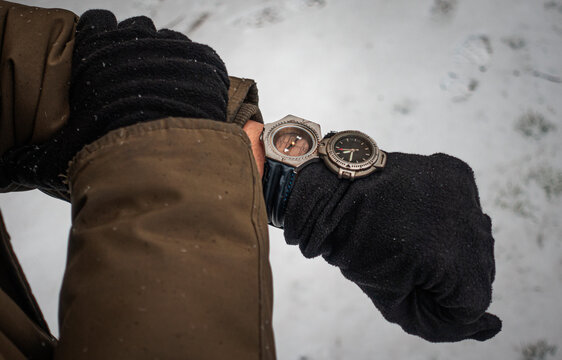 Adventurer finds his route by his compass on a snowy winter day