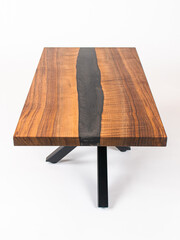 Curly Bastogne Walnut wooden coffee table with black epoxy resin and metal legs. White studio backdrop.