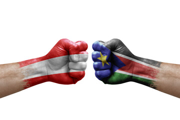 Two hands punch to each others on white background. Country flags painted fists, conflict crisis concept between austria and south sudan