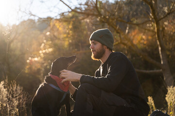 Man and his dog doing picnic in nature