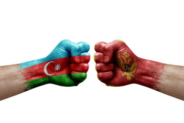 Two hands punch to each others on white background. Country flags painted fists, conflict crisis concept between azerbaijan and montenegro