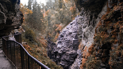 The canyon is surrounded by high rocks and nature. Water flows through it. Autumn mood.