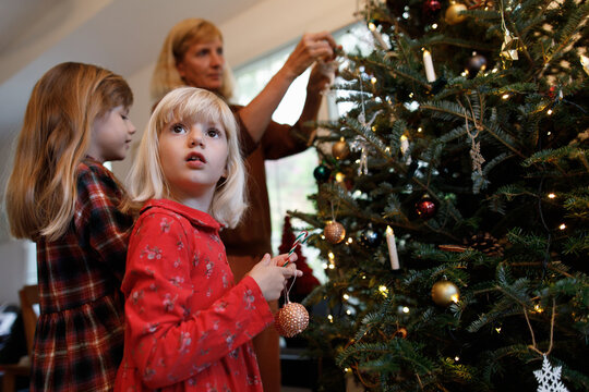 A family decorating a Christmas tree