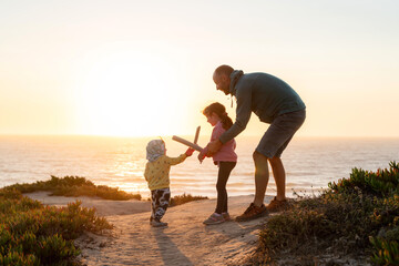 Obraz premium Happy family playing battles at sunset 