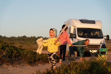 Kids playing outdoors around family motorhome