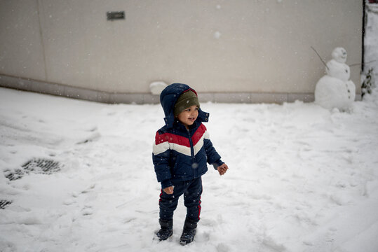 Toddler standing outdoor while snowing