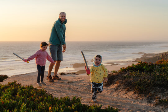 Happy family playing outdoors at sunset 