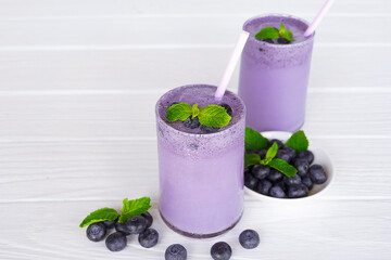 Blueberry Juice smoothies drink in a glass drink purple colorful fruit juice milkshake blend beverage healthy high protein the taste yummy in glass on white wood background.