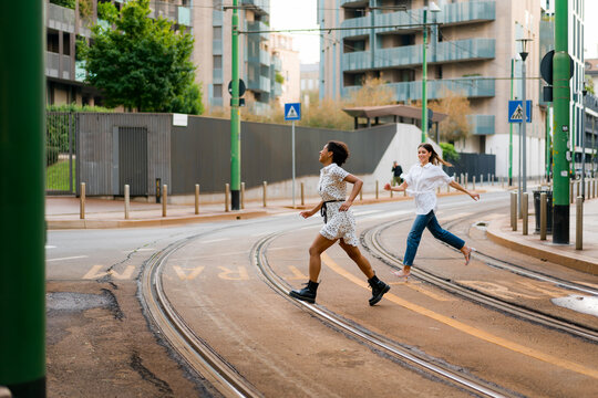 Girlfriends crossing a street - Powered by Adobe
