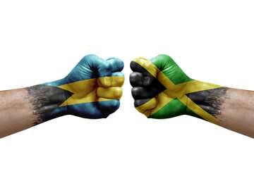 Two hands punch to each others on white background. Country flags painted fists, conflict crisis concept between bahamas and jamaica - obrazy, fototapety, plakaty