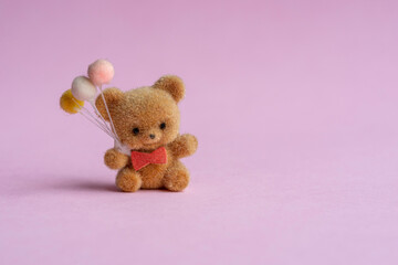 osito miniatura de adorno aislado con fondo rosa regalando globos del día del amor y la amistad