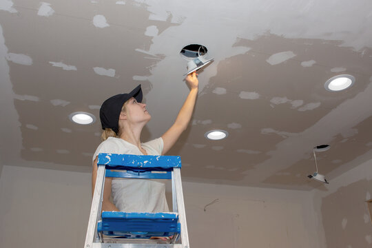 Kitchen Remodel Young Woman Installing Ceiling Light Landscape