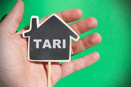 Hand holding a house with the sign "Tari" concept of Italian tax