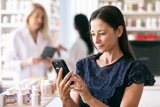 RX: Woman Uses Smart Phone In Drugstore