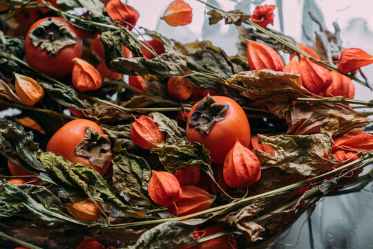 Still life with dry branches of fezalis and persimmon.