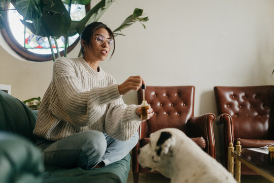 Woman giving CBD oil to a dog