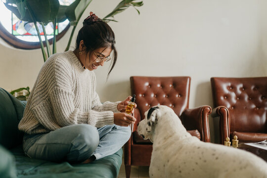 Woman giving CBD oil to a dog