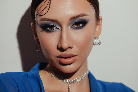 Gorgeous young woman with makeup looking at camera
