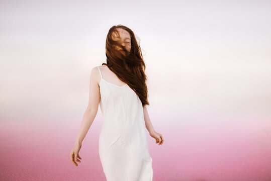Beautiful woman in a white dress in the pink lagoon