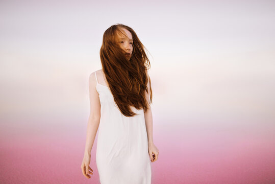 Beautiful woman in a white dress in the pink lagoon