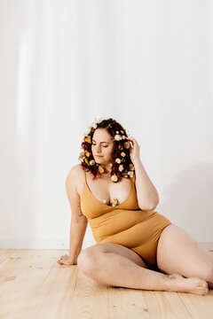 portrait of a young woman sitting on a wooden floor