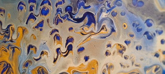 Abstract blue gold yellow art pour painting pattern close-up with canvas texture