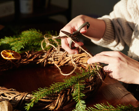 Woman making xmas festive twig wreath
