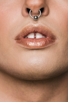Unrecognizable person with piercing in nose and makeup in lips