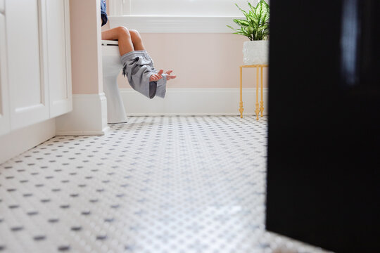 child sitting on toilet