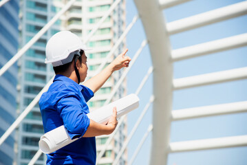 Architect at work in a construction site Engineers man construction safety work concept and construction city .Engineer Concept