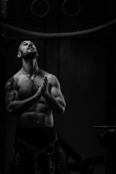 athlete with naked torso looking upside before pull-ups