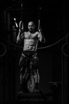 crossfit athlete with naked torso doing heavy pull-ups