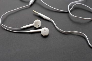 White earphones on dark background.