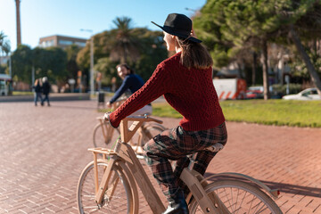 Woman riding eco bicycle in sunny city park