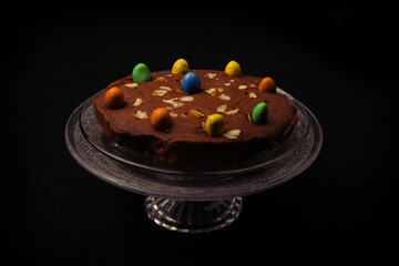 Chocolate cake decorated with sweets and dry fruits on top